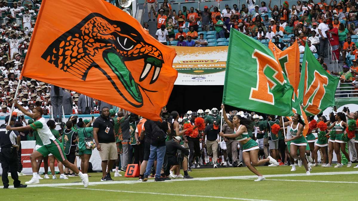 A cheerleader with a flag runs across a football field for FAMU in Tallahassee, Florida