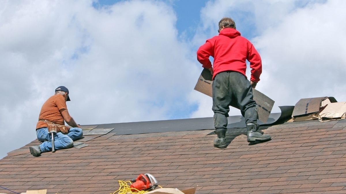 Two roofers working on a roof